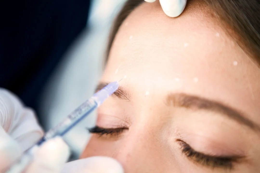 Practitioner carefully assessing the brow area before a facial treatment